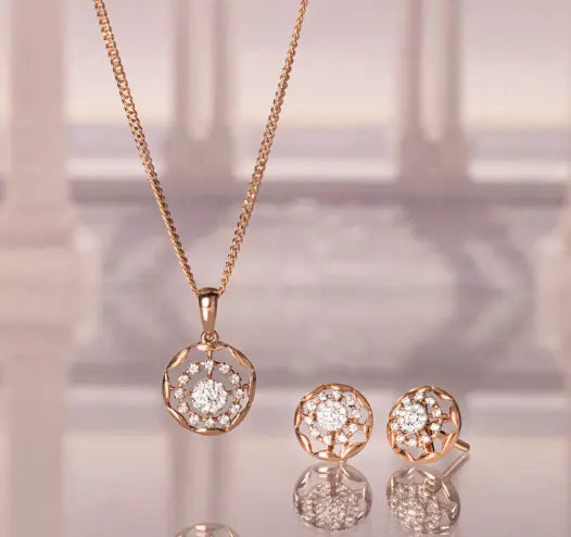 Gold pendant and earring set with intricate design.